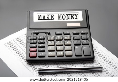 MAKE MONEY word on the calculator on the chart with pen