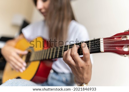 Detailed picture of a female's hand practising different chords on a guitar
