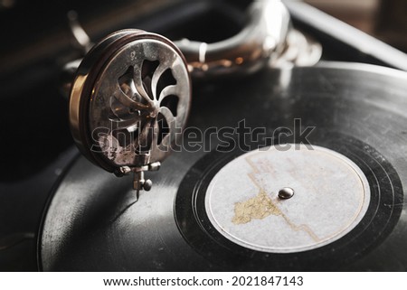 Vintage phonograph with black vinyl record plays an old music, close up photo with selective soft focus
