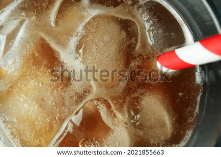 Glass of ice coffee with straw, close up