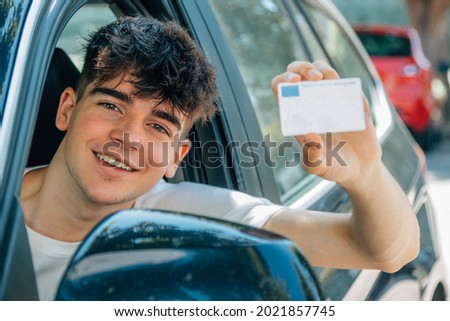 young nobel in the car with driver's license Royalty-Free Stock Photo #2021857745