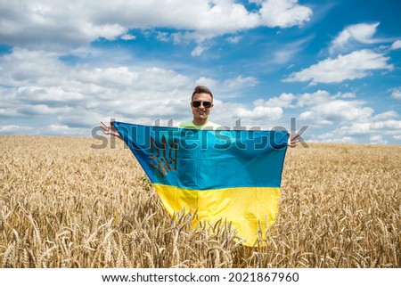 man with ukrainian flag on wheat field in summer. lifestyle