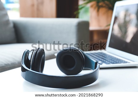 Modern headphones on table in room Royalty-Free Stock Photo #2021868290