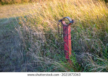 Red post on a field for a barrier. High quality photo