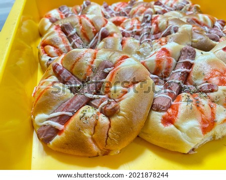 Mini sausage or hotdog pizza on a yellow tray