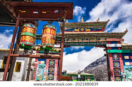 artistic buddhist decorated entry gate of city with religious wheels and bright blue sky at morning image is taken at sela pass tawang arunachal pradesh india. it is one of the highest passes. Royalty-Free Stock Photo #2021880839