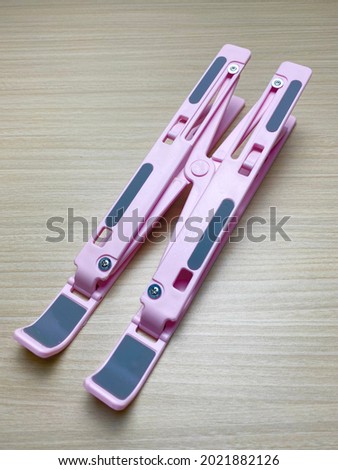 Pink Notebook Laptop Plastic Folding Stand on wooden Background