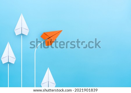 Business concept for new ideas creativity and innovative solution, Group of white paper plane in one direction and one orange paper plane pointing in different way, copy space
