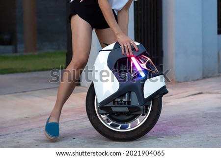 Electric unicycle. Hand of woman holding on mono wheel. Royalty-Free Stock Photo #2021904065