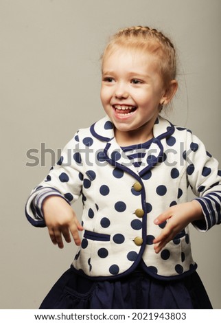 cute laughing girl child over grey background, happy childhood