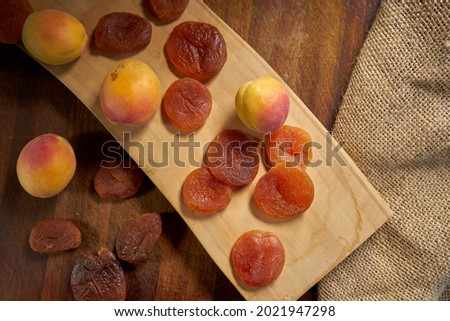 Dried and fresh apricots on a wooden surface                            