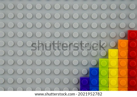 minimalistic concept of LGBT and human rights, flag folded like a LGBT flag from a children's constructor, on a gray background,
