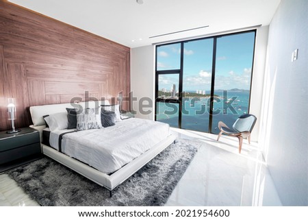 Modern and luxurious hotel bedroom with views of Pattaya beach and skyline. Condo or 5-star upscale accommodation. Royalty-Free Stock Photo #2021954600