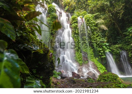 Tropical landscape. Beautiful hidden waterfall in rainforest. Adventure and travel concept. Nature background. Slow shutter speed, motion photography.