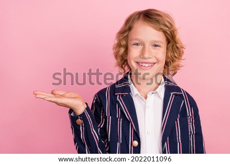 Photo of young school boy happy positive smile hold hand product promo ads suggest sale isolated over pink color background