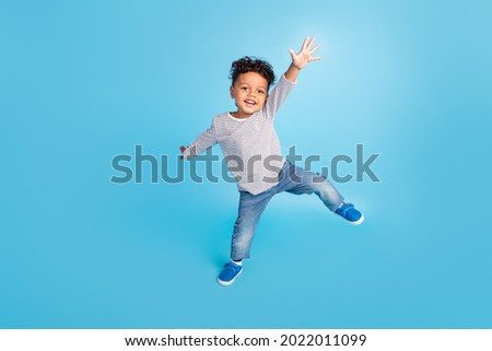 Full length body size view of attractive cheerful carefree boy dancing good mood isolated over bright blue color background Royalty-Free Stock Photo #2022011099