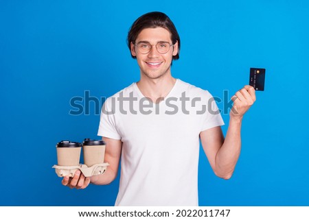 Photo portrait brunet man keeping credit card coffee in glasses isolated vivid blue color background