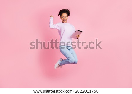 Full size photo of excited smiling good mood afro girl jumping raise fist in triumph isolated on pink color background