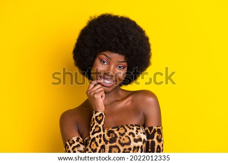 Photo portrait woman wearing curly hairstyle printed leopard top biting nail smiling isolated vivid yellow color background