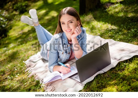 Full length photo of young girl happy positive smile remote learning online lesson laptop write notes nature park