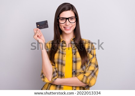 Photo of young attractive woman happy positive smile hold credit card money isolated over grey color background