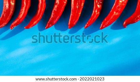 Red hot chili peppers from above on a blue background