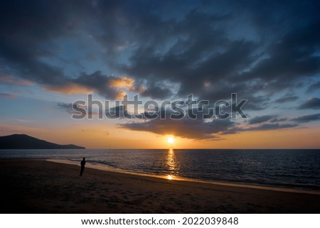 silhouette of man looking at sunset on sea with tranquil atmosphere beach in phuket island, Thailand