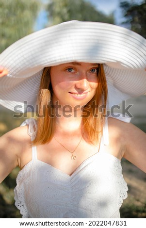 Woman Outdoors Portrait. Young Lady In Summer Hat And White Dress Walking In Forest.