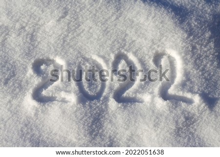 2022 written on the snow. Happy new year. Sunny winter day.