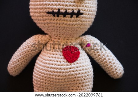 voodoo doll lying on a black background.