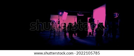 Silhouette images of film production. behind the scenes or b-roll of making video commercial movie. Film crew lightman and cameraman working together with film director in studio. Film industry. Royalty-Free Stock Photo #2022105785