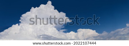 Panorama image of white huge cumulonimbus cloud rising up in the blue sky. Cloudscape, Japan