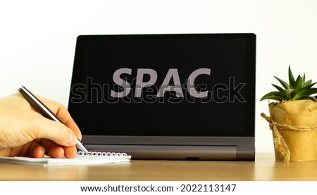 SPAC, special purpose acquisition company symbol. Tablet with words 'SPAC, special purpose acquisition company on white background, copy space. Businessman hand. Business and SPAC concept.
