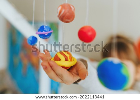 Solar system model hanging over the kid bed. DIY activity for children concept. Selective focus.