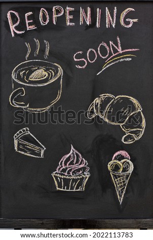 Part of blackboard with drawn pastry items and drink and reopening announcement