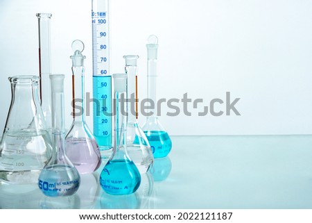 Set of laboratory glassware (beaker) filled different color liquid with reflection  on a white background. Drug development concept.                              