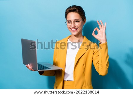 Photo of young business woman happy positive smile use laptop show okay alright sign isolated over blue color background