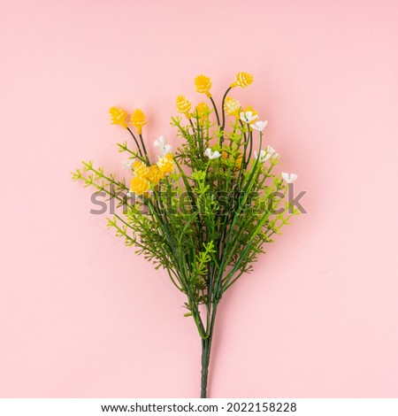 Artificial flower on light pink background.