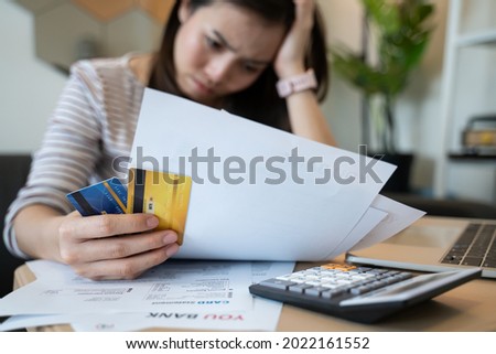 stressed woman trying money to pay credit card debt and many expenses bills such as electricity bill,water bill,internet bill,phone bill during covid-19 or coronavirus outbreak at home Royalty-Free Stock Photo #2022161552