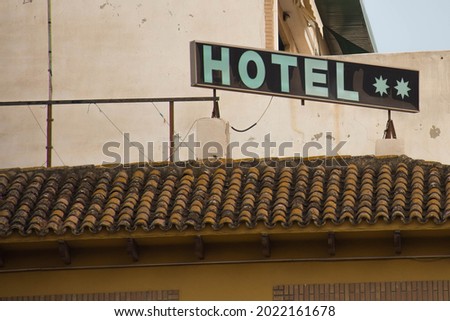 Sign at the top of an old hotel indicating that it is two stars.