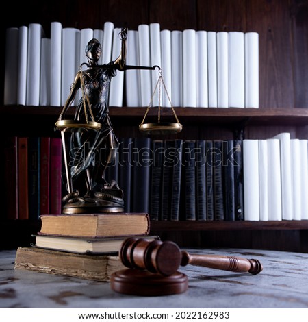 Scales of Justice, Lady Justice, law library concept, Law books in the background.
