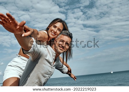 Happy young couple enjoying a solitary beach back riding. CLose up view. Copy space.