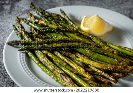 Grilled asparagus on white serving dish. Royalty-Free Stock Photo #2022219680