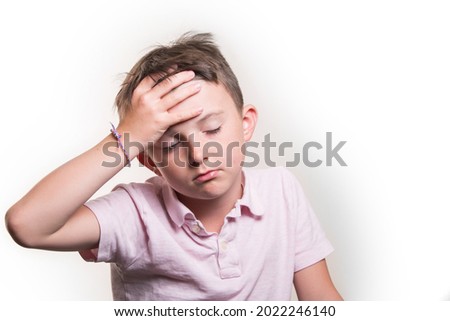 A portrait of a Caucasian boy, holding his head, closed eyes, wearing a polo shirt, isolated on white background