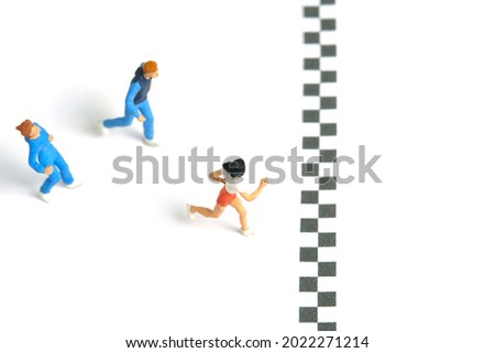 Miniature people toy figure photography. Running race competition winner, isolated on white background. Image photo
