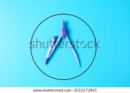 A picture of geometry compass with circle on blue background