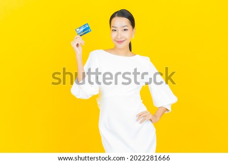 Portrait beautiful young asian woman smile with credit card on color background