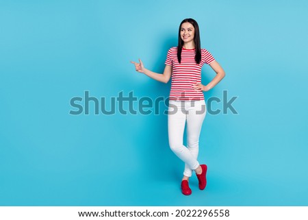 Full body photo of young girl happy smile look indicate finger empty space select suggest promo isolated over blue color background