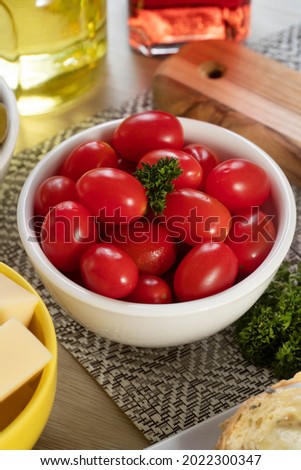 Appetizer jars with cheese, olives and cherry tomatoes.