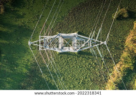 Transmission tower or pylon in top view. That substation, utility, infrastructure or steel structure for network of electrical grids system to carry high-voltage wire, cable or overhead power line. Royalty-Free Stock Photo #2022318341